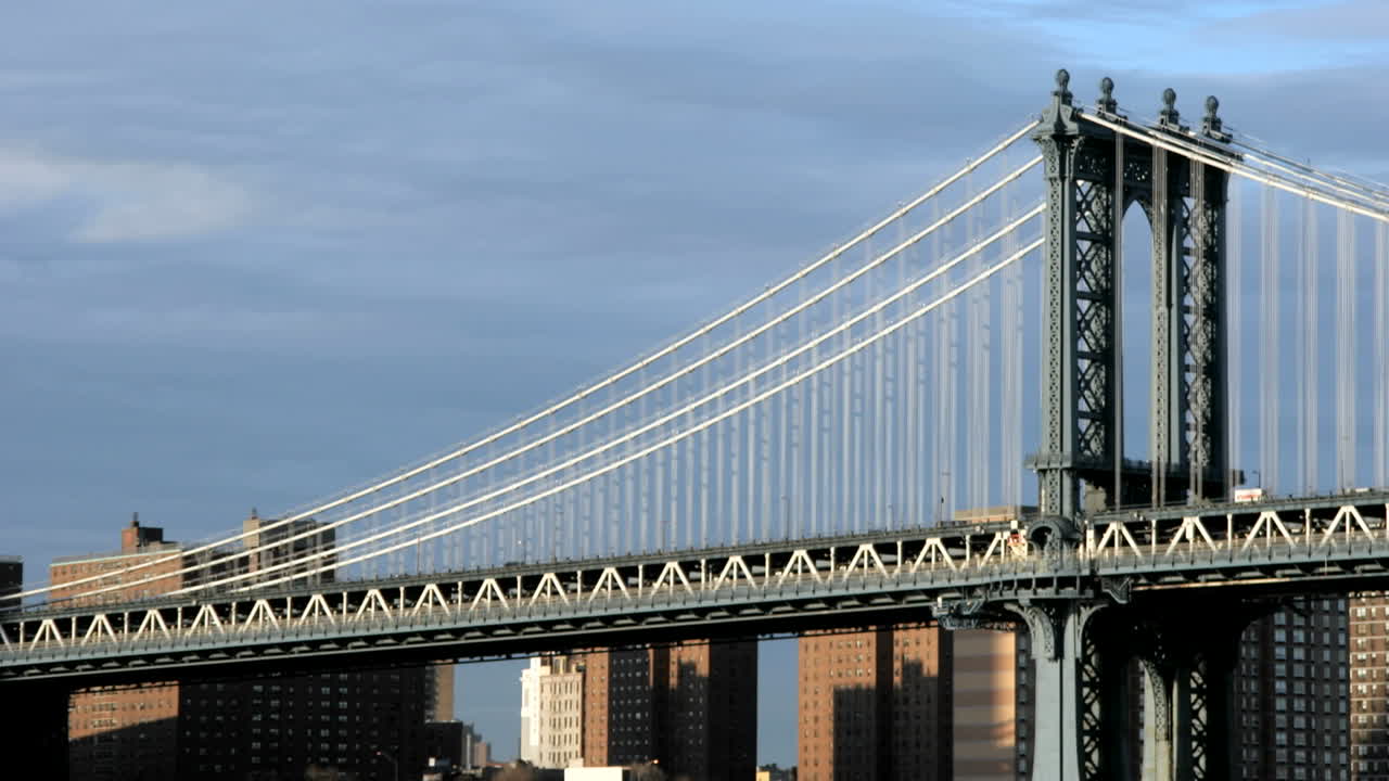 어두워지는 흐린 하늘과 짙은 안개 아래 맨해튼 다리를 가로지르는 가속 교통