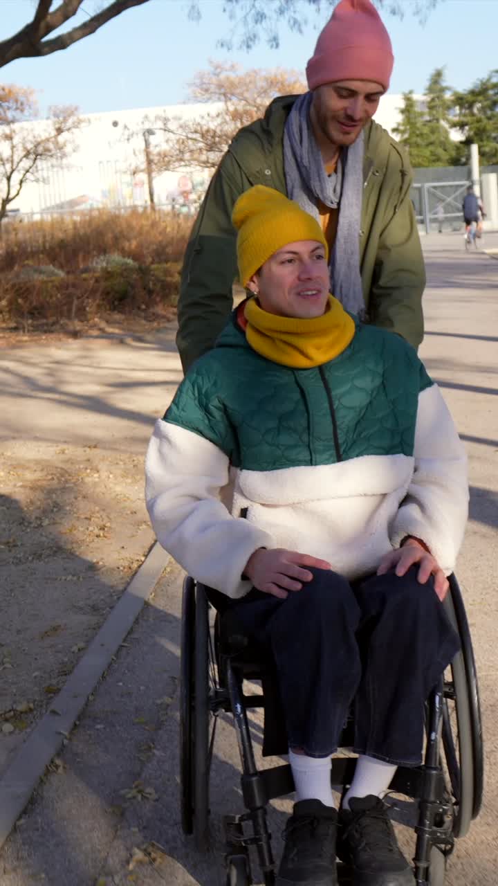 Man Pushing Friend in Wheelchair in Park