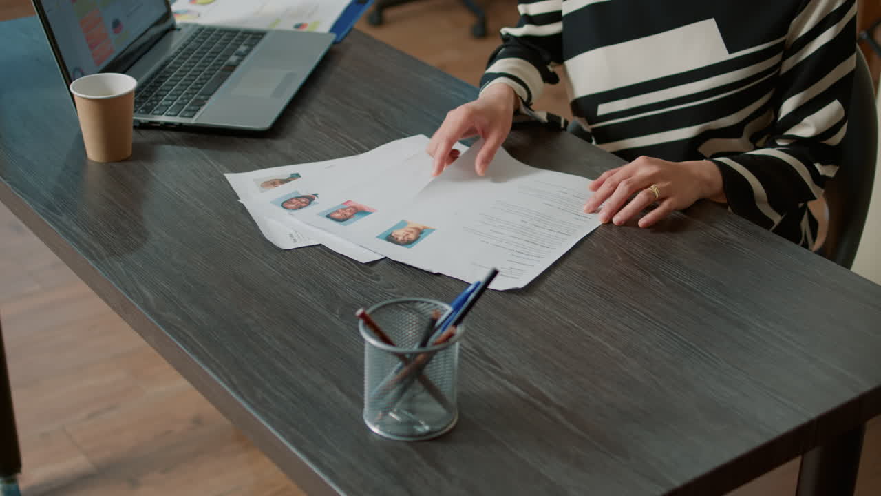 Female HR employee looking at cv resume to hire candidates