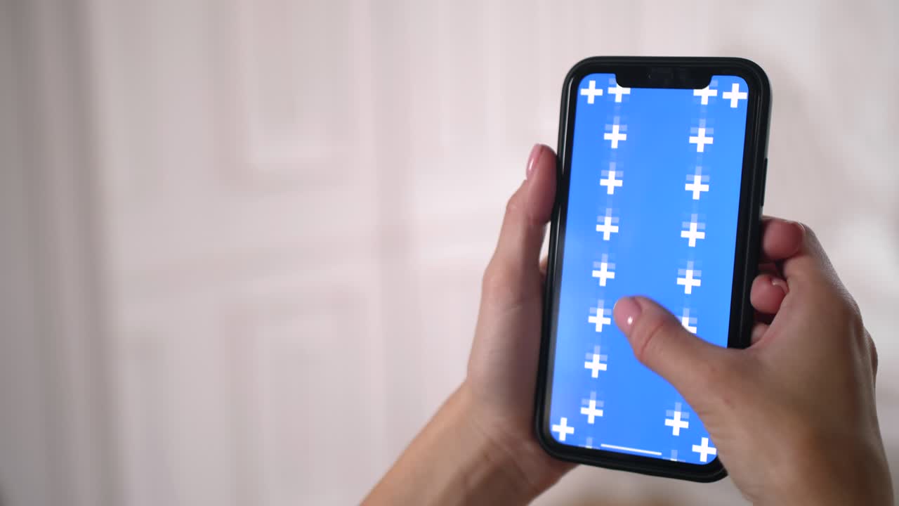 여성 슬라이드는 스마트폰 앱에서 파란색 크로마 키 스크린을 위아래로 스크롤합니다.
