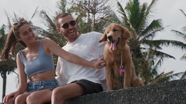 una pareja acaricia a su perro al aire libre