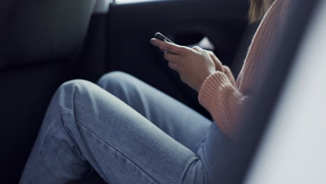 Hands,-phone-and-woman-typing-in-car