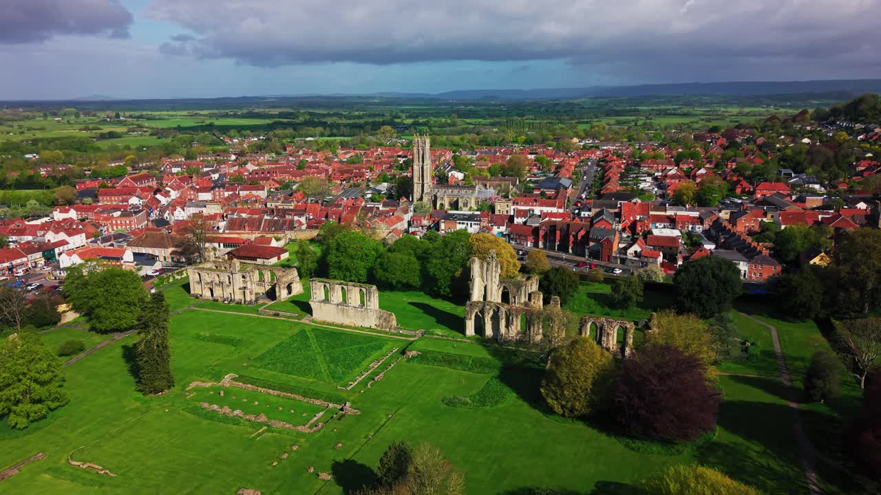 Veduta aerea delle rovine dell'Abbazia di Glastonbury con la città circostante e la cattedrale nel Somerset, Inghilterra, che mostra il sito storico e il paesaggio urbano nel Regno Unito.