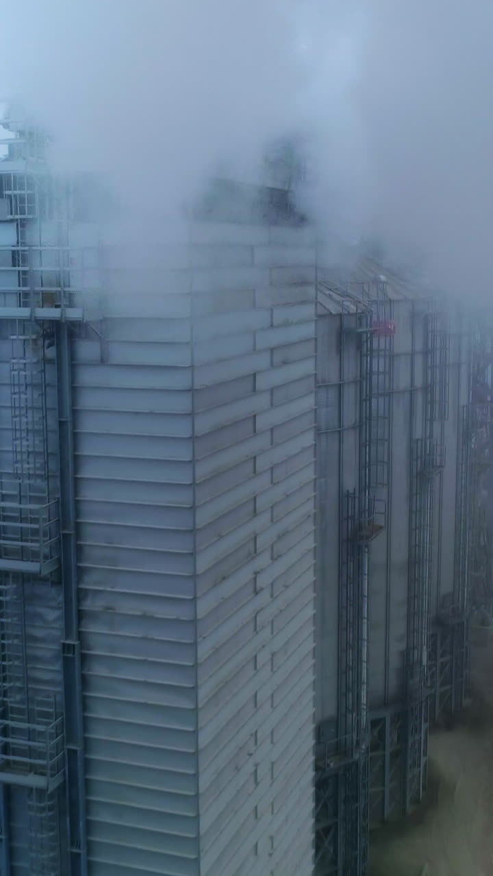 Drone shot of industrial grain elevator. Granary big construction storage. Vertical video