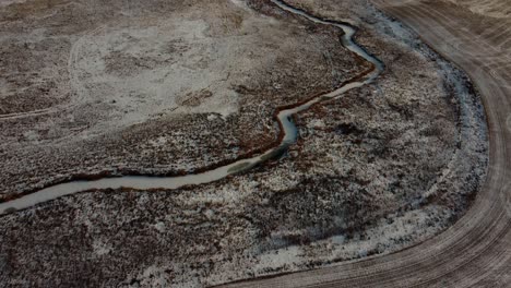volando sobre un arroyo congelado en medio del campo de un granjero en invierno en calgary