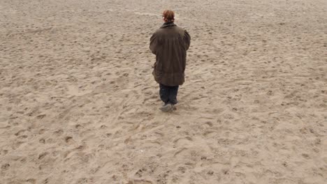 young woman walking, sitting down, taking a photo and lying down on a beach