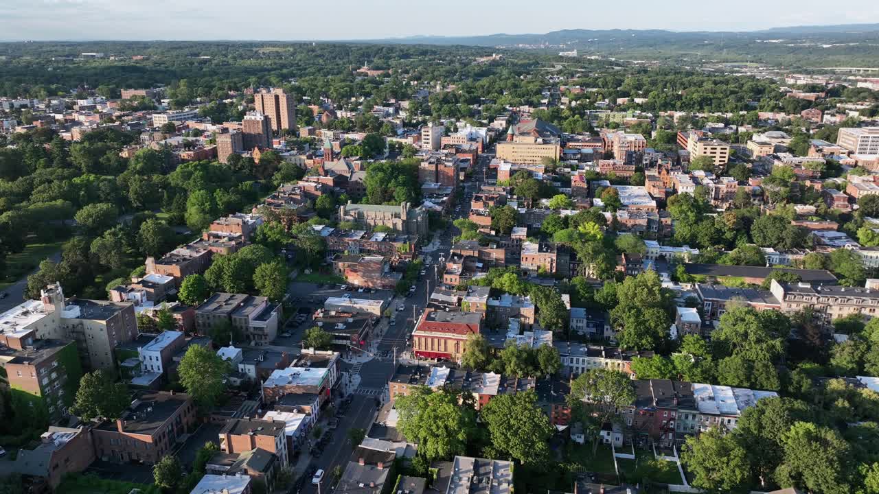 Golden hour in American city of Albany, USA. Aerial wide shot. Sunset time in small town. Green trees in downtown. Summer evening in America