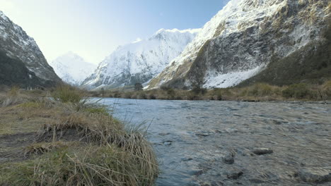 pequeño arroyo con montañas cubiertas de nieve en el fondo en una fría mañana de invierno en la isla sur de nueva zelanda