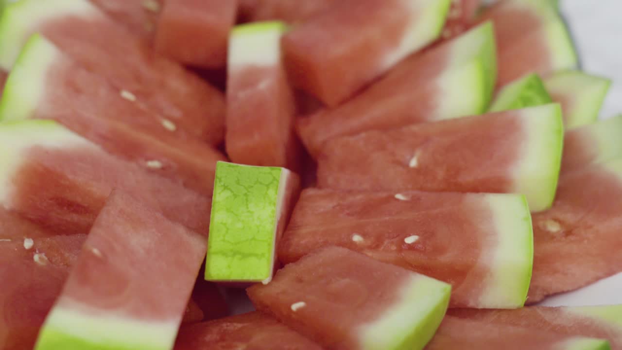 파티를 위한 트레이에 은 씨 없는 수박의 작은 조각을 넣습니다.