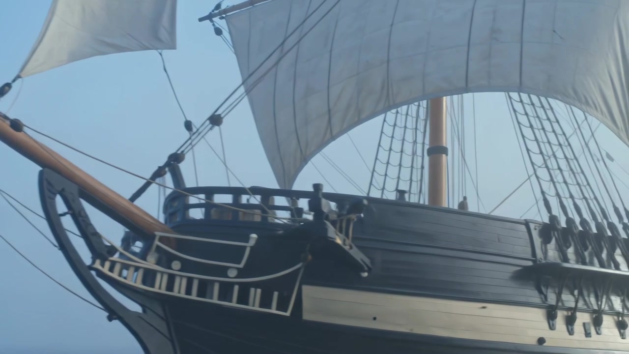 Telecamera panoramica che rivela la prua di una classica nave di legno in mare, con bompresso, polena e sartiame che si muovono.