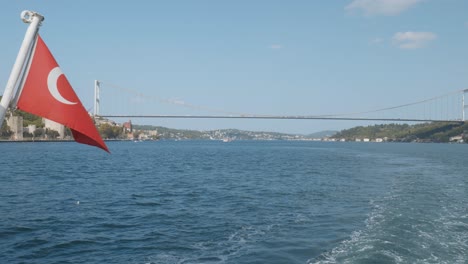 cruising bosphorus strait suspension bridge turkish flag stern of boat