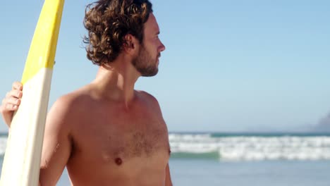 joven con una tabla de surf en la playa