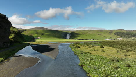 skogafoss from the distance famous waterfall in iceland aerial shot over a river