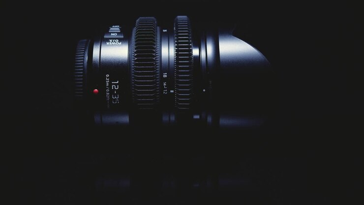 Film lens is artistically lit on a black background. Advanced optical technology.