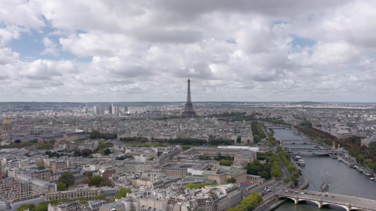 A breathtaking steady aerial drone shot captures the Eiffel Tower rising above Paris with the Seine River winding through the city’s historic skyline
