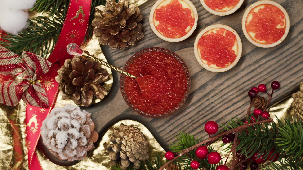 Hand Stirring Red Caviar Amidst Festive Christmas Decorations