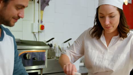 Male-and-female-baker-using-pasta-cutter-in-kitchen-4k