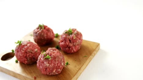 Raw-meat-balls-on-wooden-board