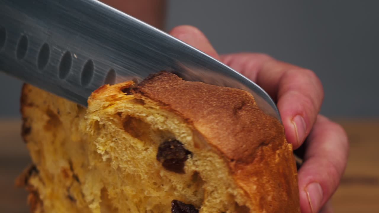 Traditional English Christmas cake tied with a jute thread on the black background. Italian classic Panettone .Pastry Chef sprinkles powdered sugar through a sieve on the fruit Easter cake with raisins. High quality 4k footage