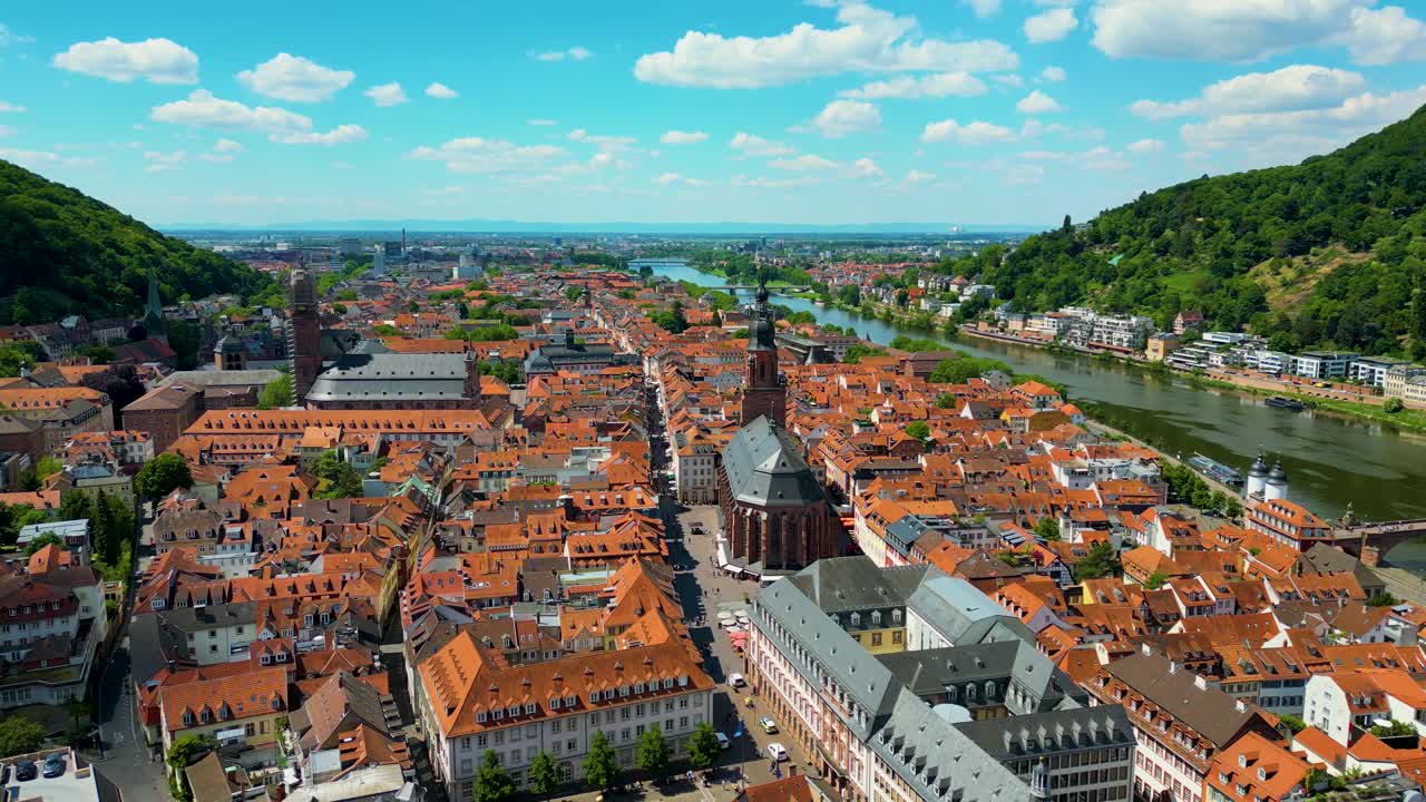 4K Aerial Drone Video of the Beautiful Homes with Red Terracotta Tile Roofs and Historic Heiliggeistkirche Church along the Neckar River in Heidelberg, Germany