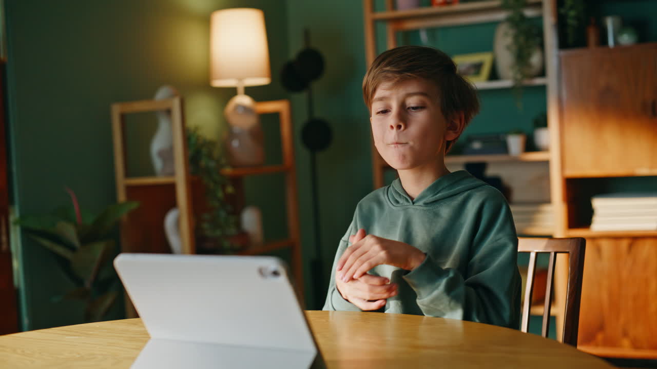 Boy talking tablet webcam having online meeting in modern apartment closeup
