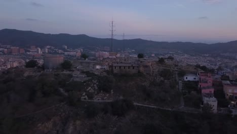 Panning-aerial-drone-shot-starting-from-los-Bunkers-till-the-sea-of-Barcelona-while-sunrise,-Spain