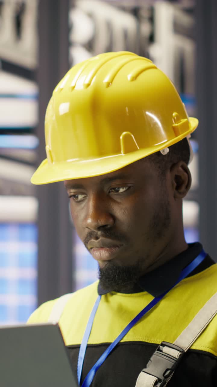 Vertical video Industry 4.0 plant engineer following maintenance procedures to mend bugs