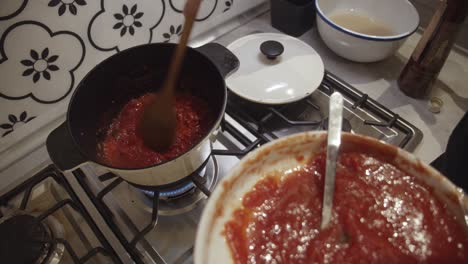 mezclar salsa de tomate fresco con tomate frito cortado en dados dentro de una olla caliente en la estufa de gas