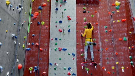 mujer practicando escalada en roca en el estudio de fitness 4k