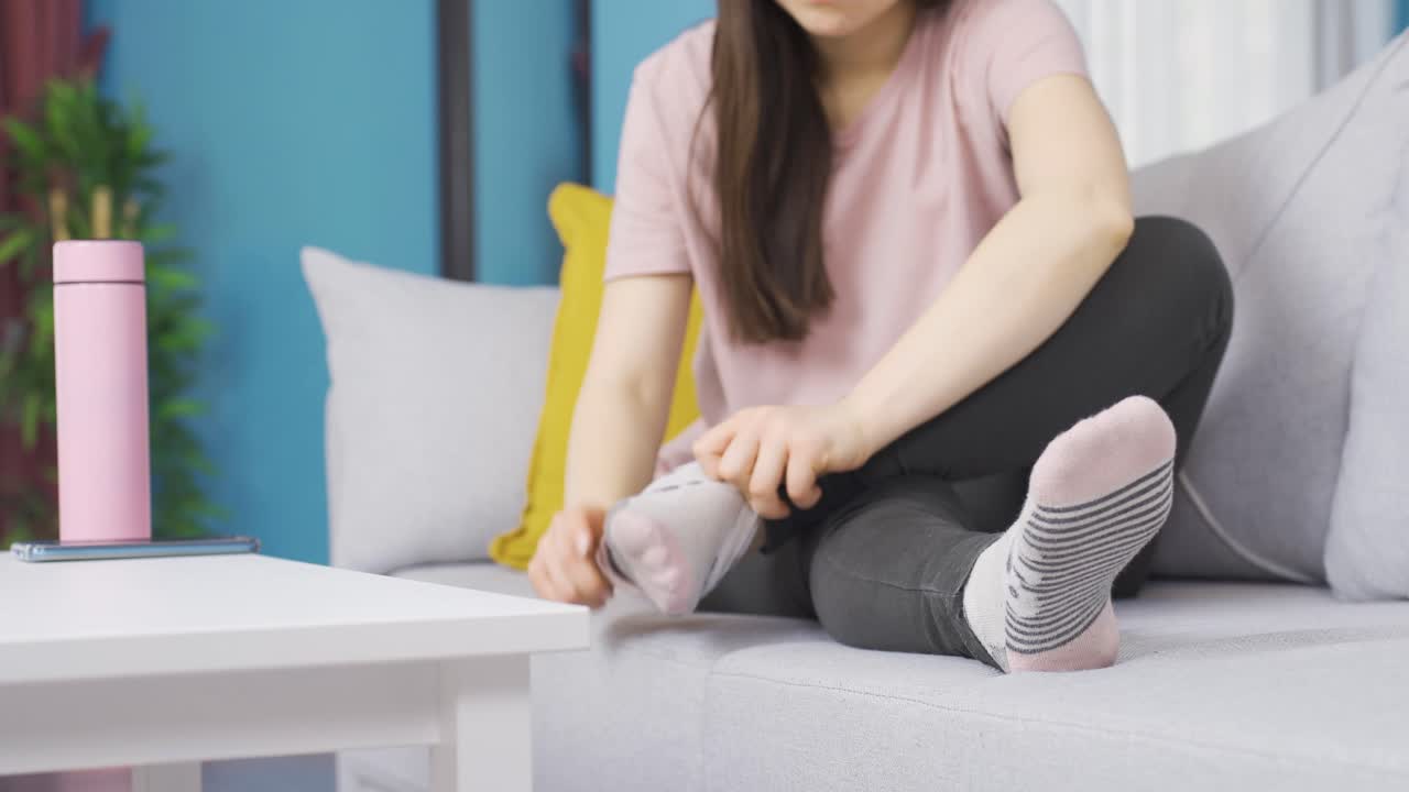 양말을 착용하세요. 젊은 아시아 여성이 양말을 착용합니다.