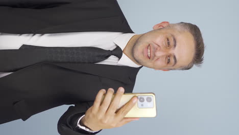 Vertical-video-of-Video-of-businessman-making-video-call-on-phone.