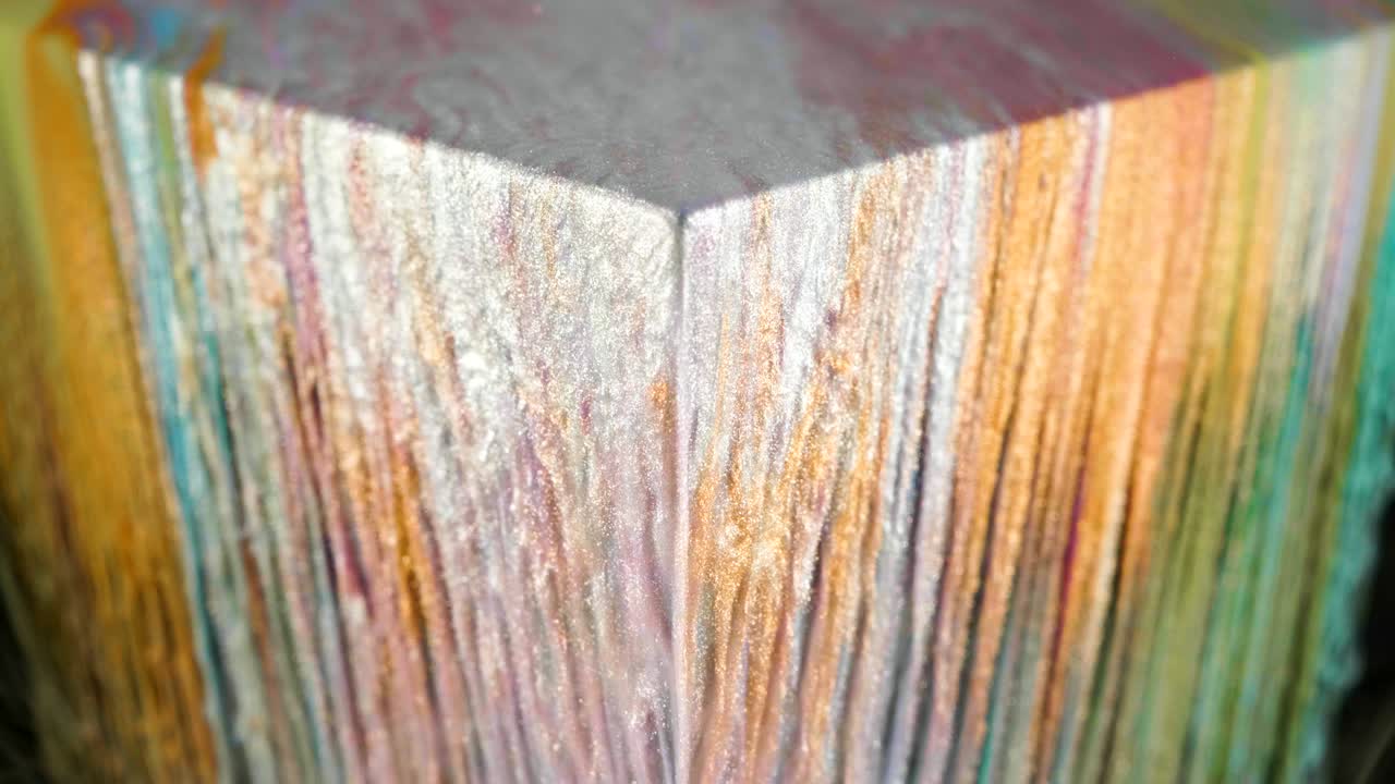 pintura de tinta multicolor fluye lentamente desde el cubo bajo el agua