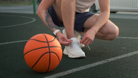 man tying his shoes on a basketball court