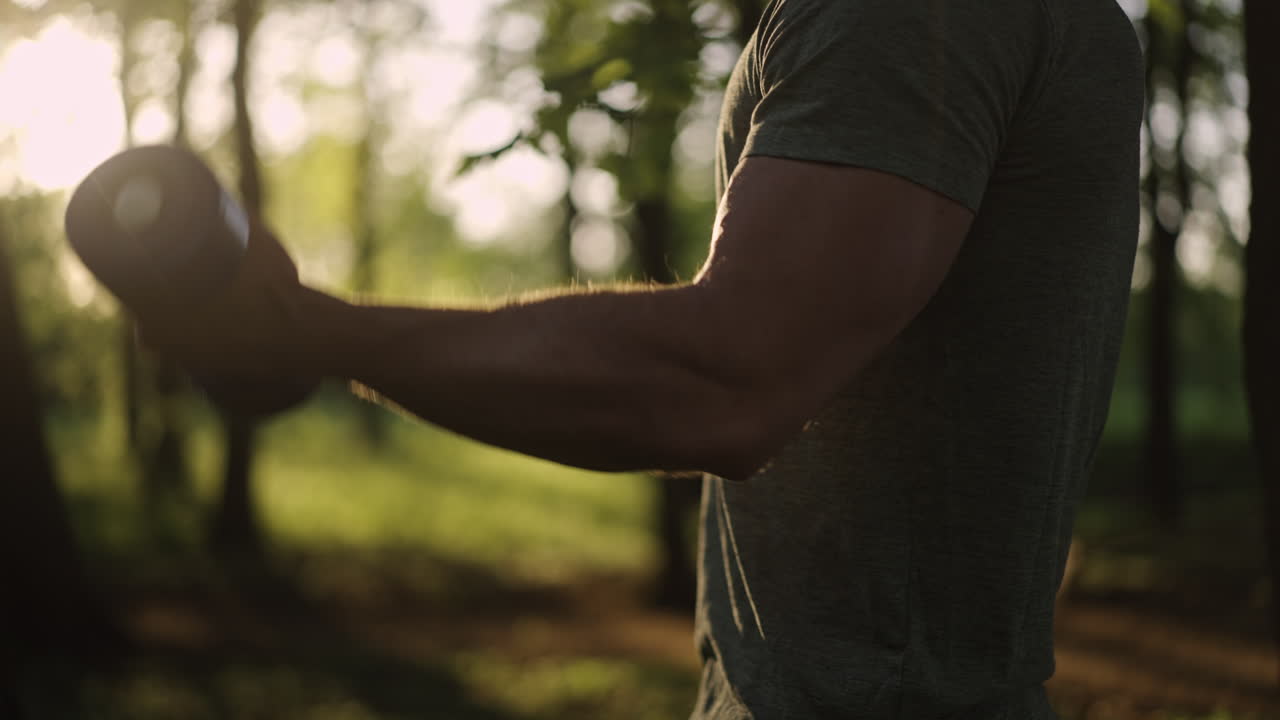 Man working out with dumbbells in the forest