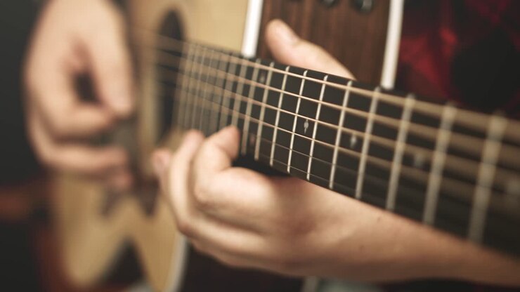 Close up of a western acoustic guitars neck and strings while a guitar solo is being played on it by a professional musician