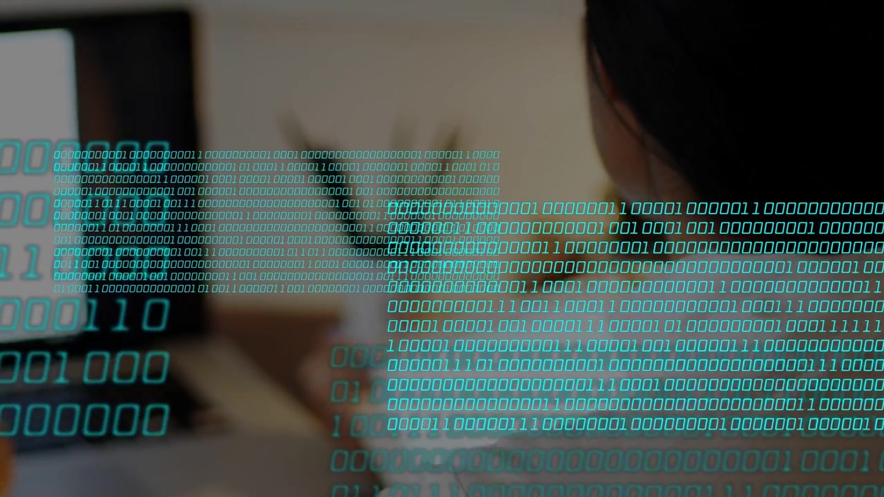 Woman comparing tablet to laptop, adjusting it causing teal binary overlay growing over tech desk