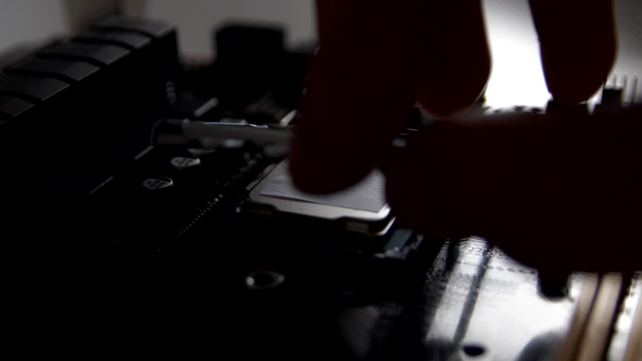 Man's hand puts the processor into the motherboard socket