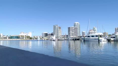 4k video of small sailboat sailing past yachts in florida marina