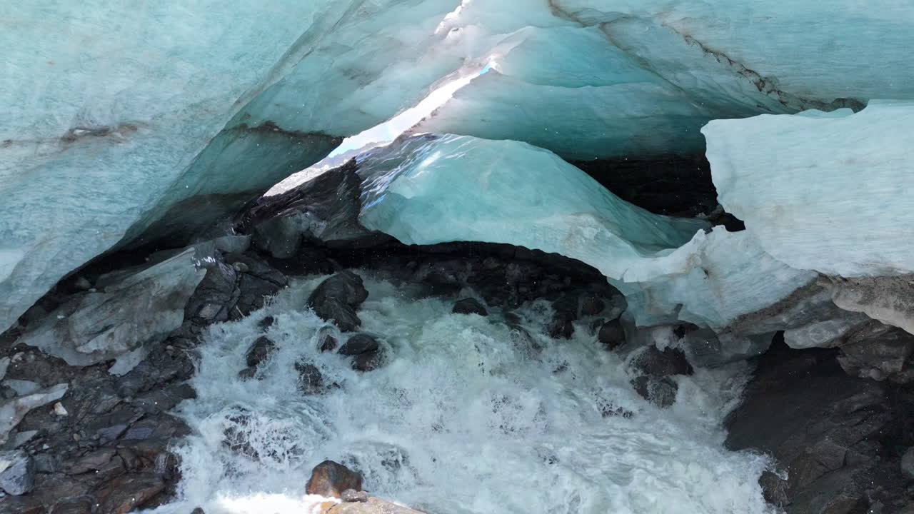 Rushing stream under ice cave at Morteratsch Glacier, serene and powerful