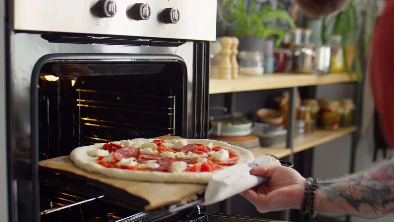 Uomo che Inforna la Pizza nel Forno
