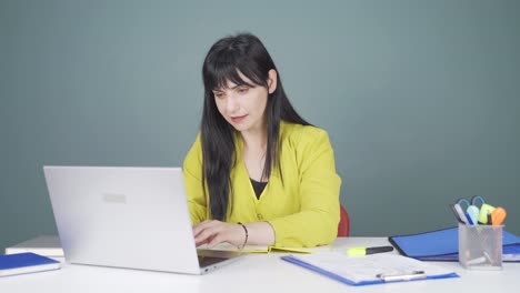 행복한 표정으로 노트북에서 일하는 여성.