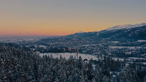 stunning drone winter aerial shot pine trees moving onto hotel bachleda poland during golden hour