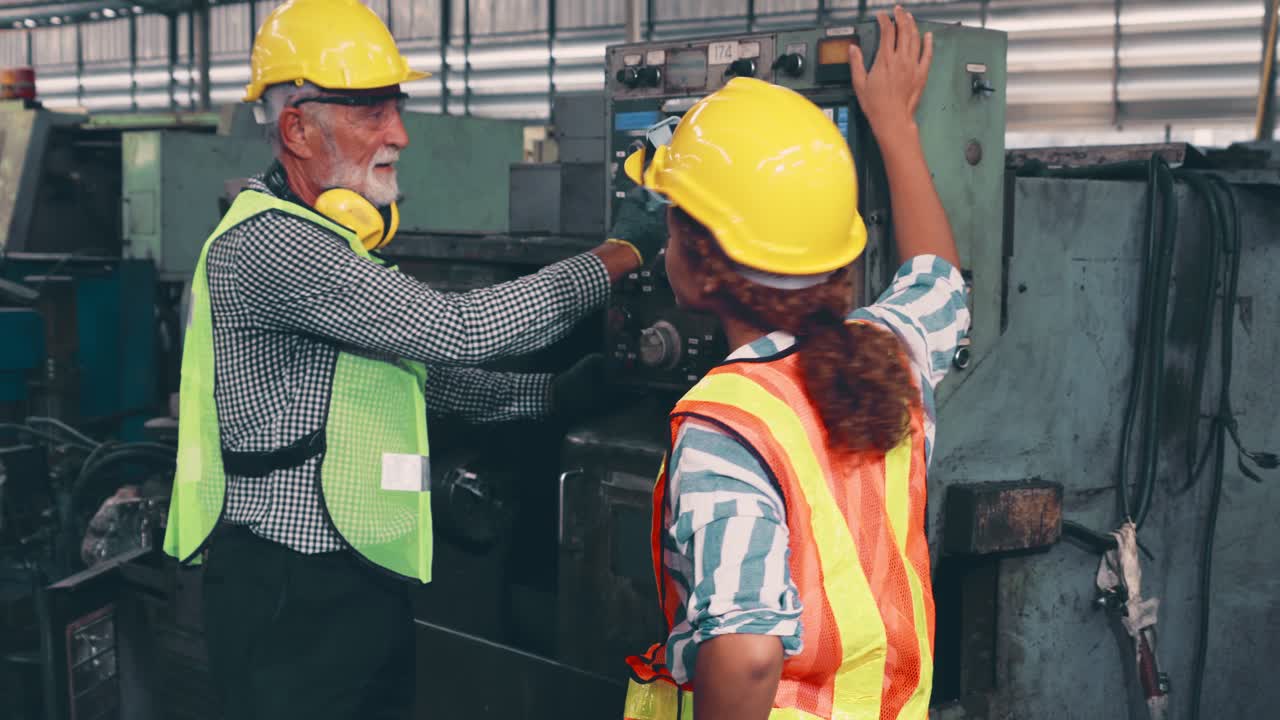 Group of factory workers using machine equipment in factory workshop