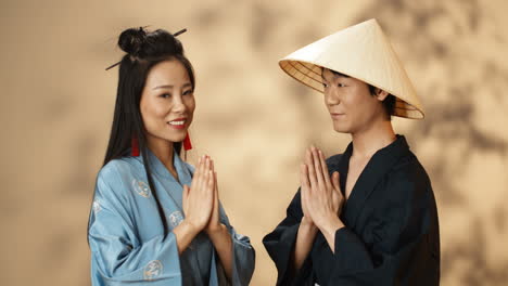 asian young couple in traditional chinese costumes bowing