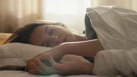 caucasian woman is unsatisfied from ringing alarm clock at morning.