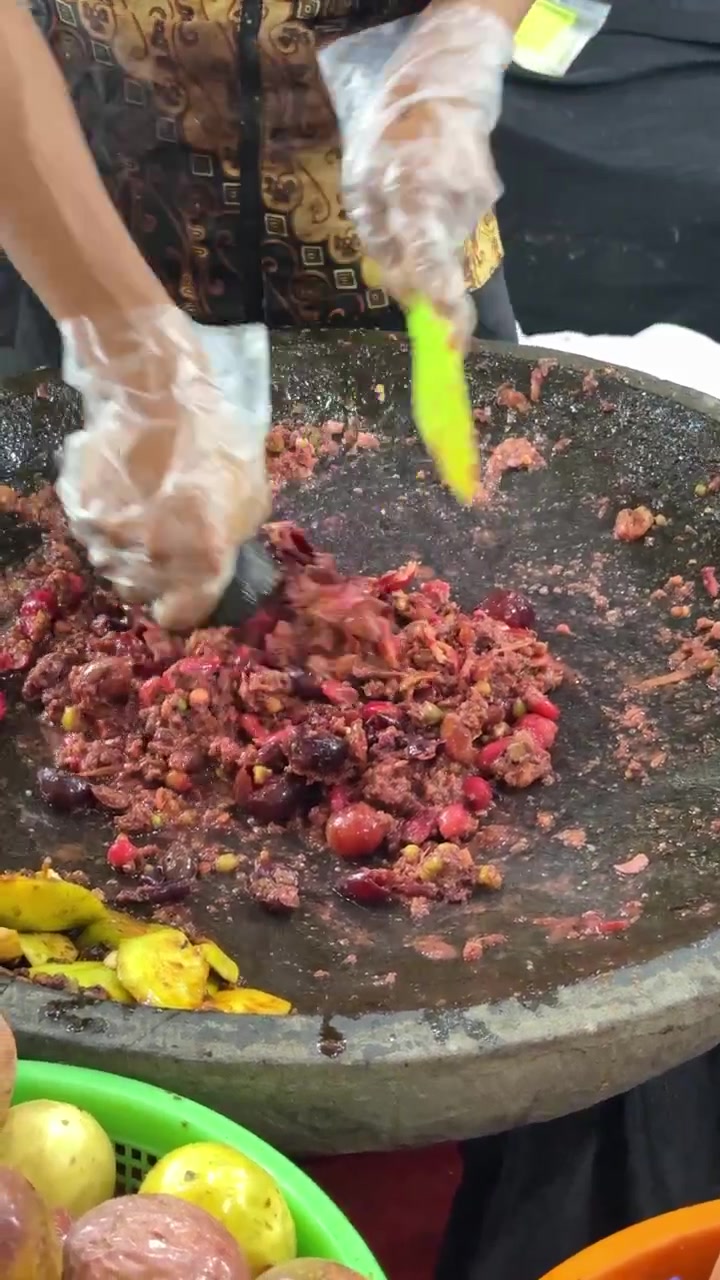 Pedagang Kaki Lima Mengulek Buah Segar dengan Cobek dan Ulekan
