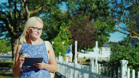 woman with tablet on suburban street