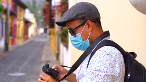 latin photographer with face mask checking pictures