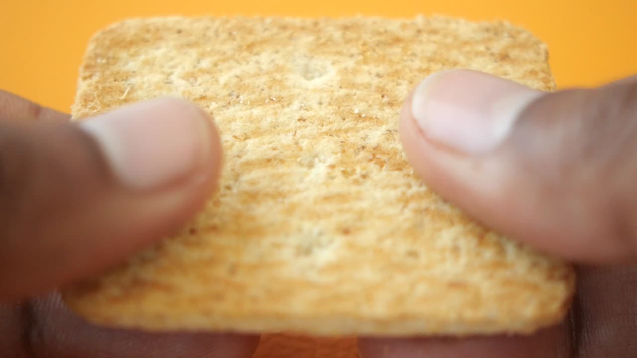 Hands holding a broken cracker