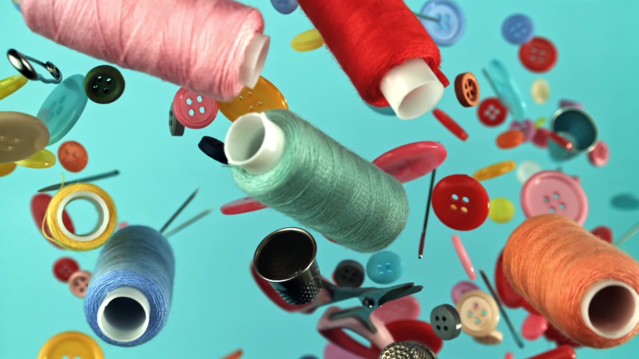 Vibrant Sewing Tools and Buttons Falling on Blue Background